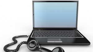Laptop mit einem angeschlossenen Telefonhörer.